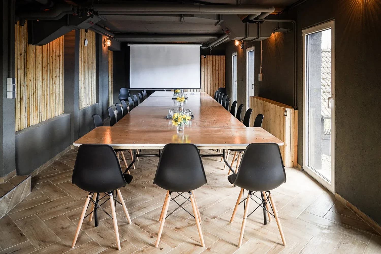Workspace mit langer Tafel und Leinwand