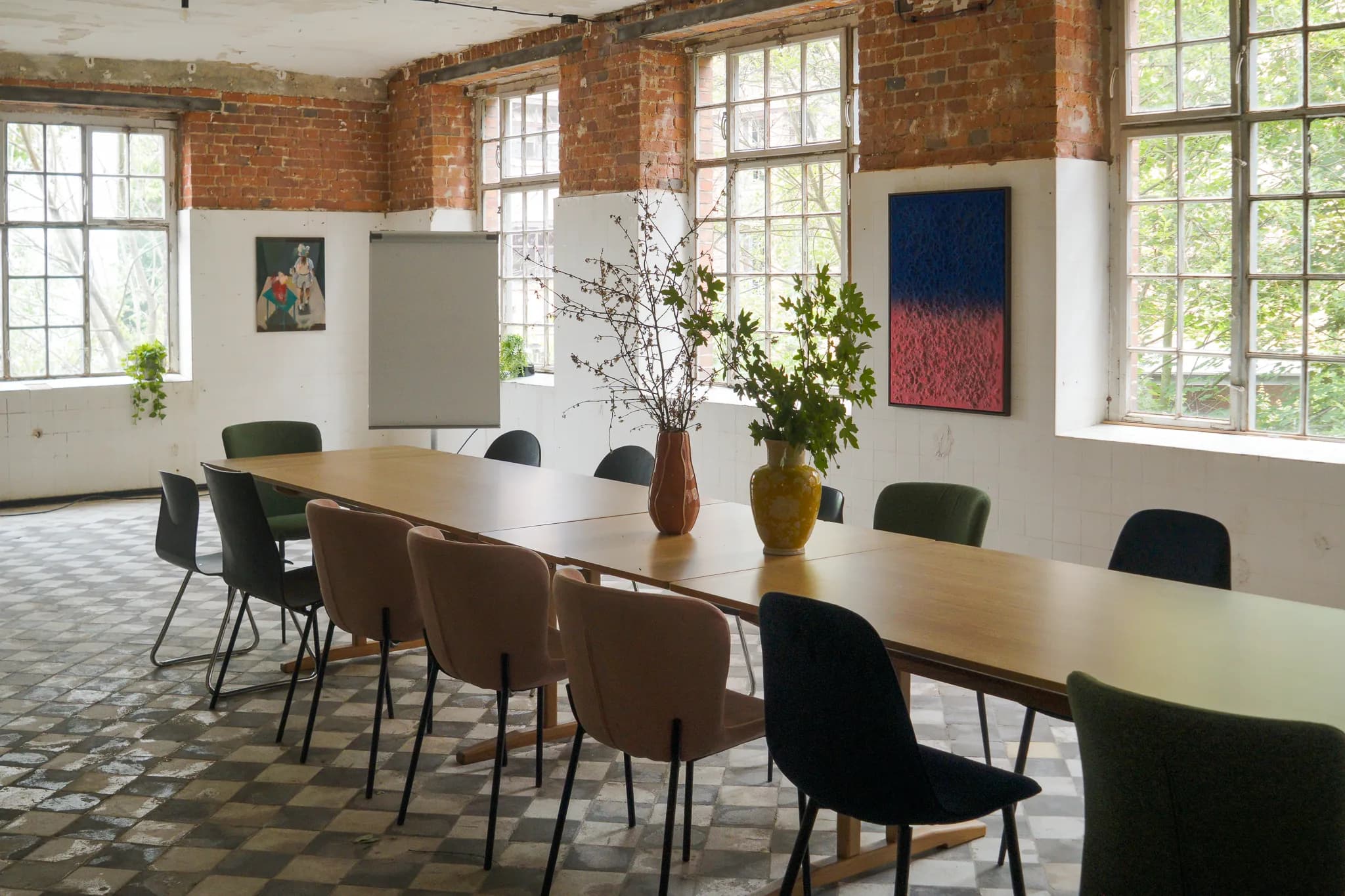 Seminarraum mit langem Holztisch und Flipchart