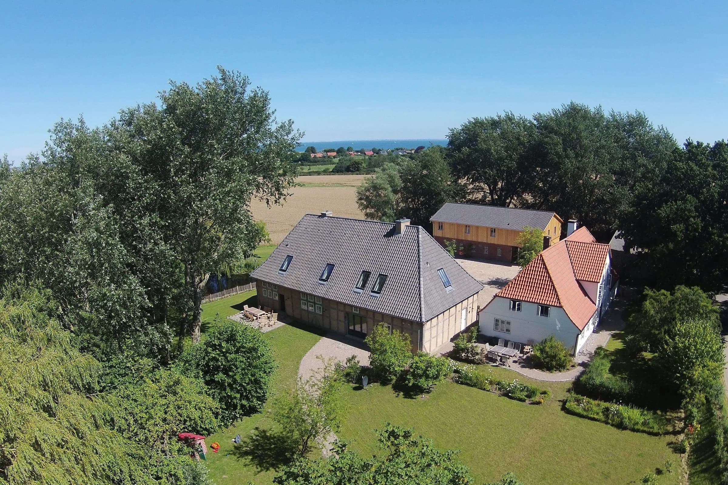 Luftbild der Hofanlage mit Garten und Ostsee im Hintergrund