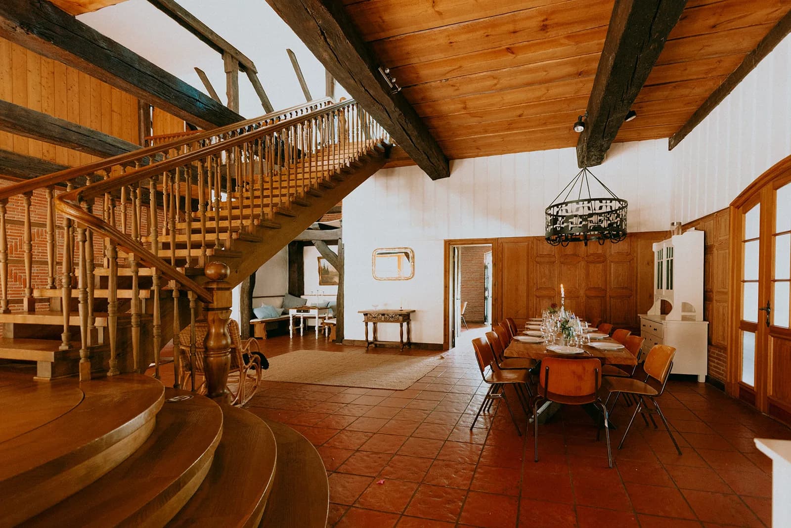 Hohe Diele mit Holztreppe und Esstisch